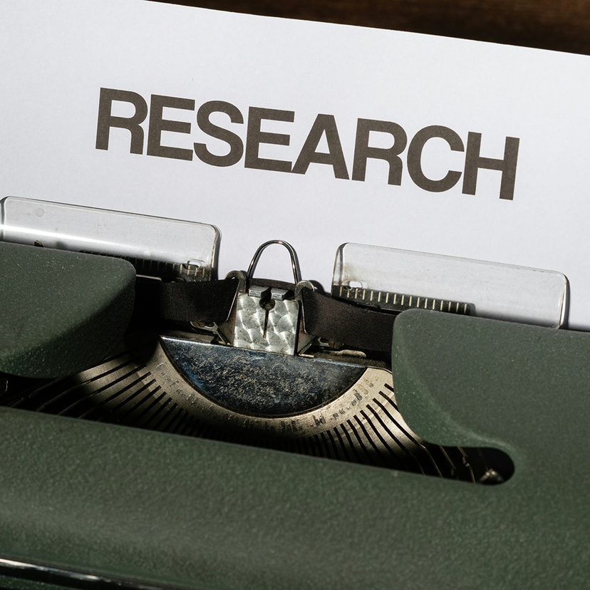 The words research in capital letters on a pieced of paper sitting in a typewriter