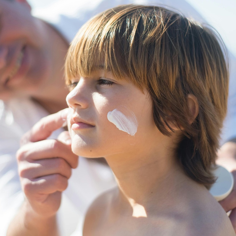 Man applying sunscreen on a child's face