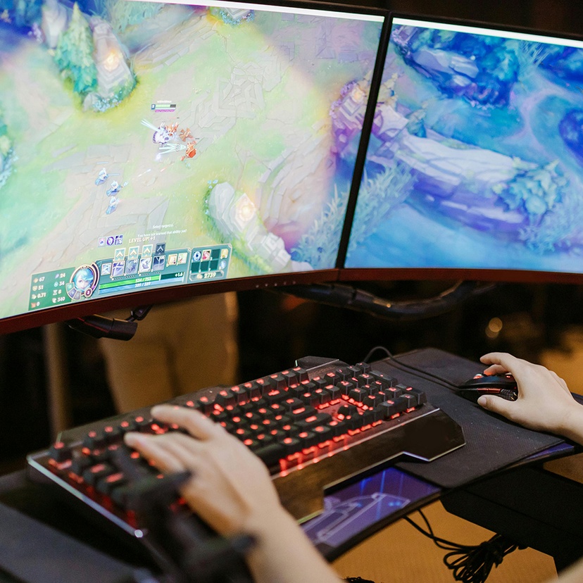 Woman in front of a computer screen playing esports League of Legends