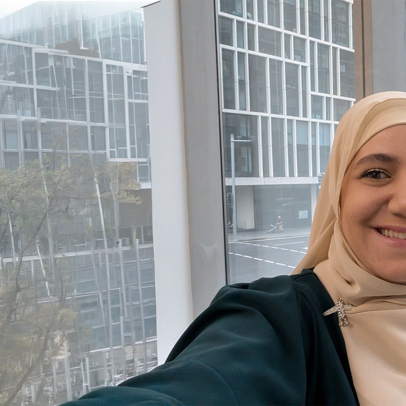 Woman standing in front of a glass window smiling