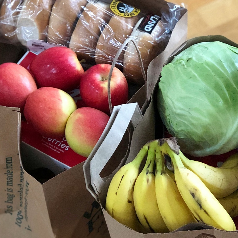 Paper bags with groceries including fruits and vegetables and bread