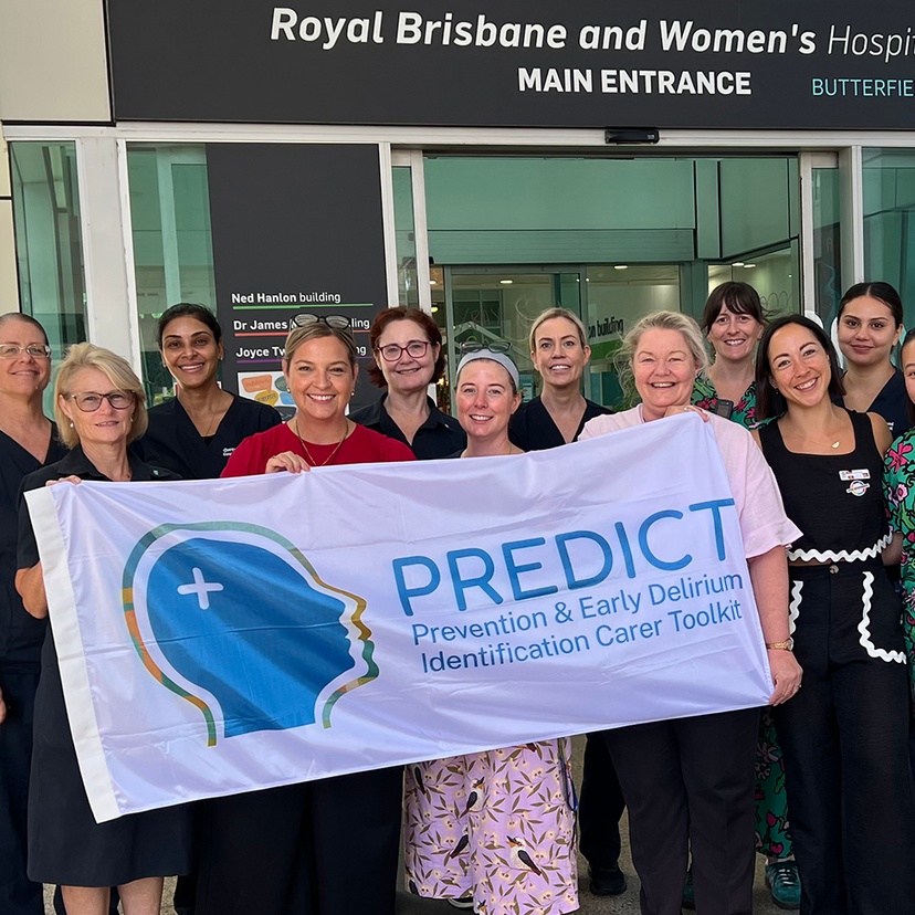A group of people outside a hospital holding a banner