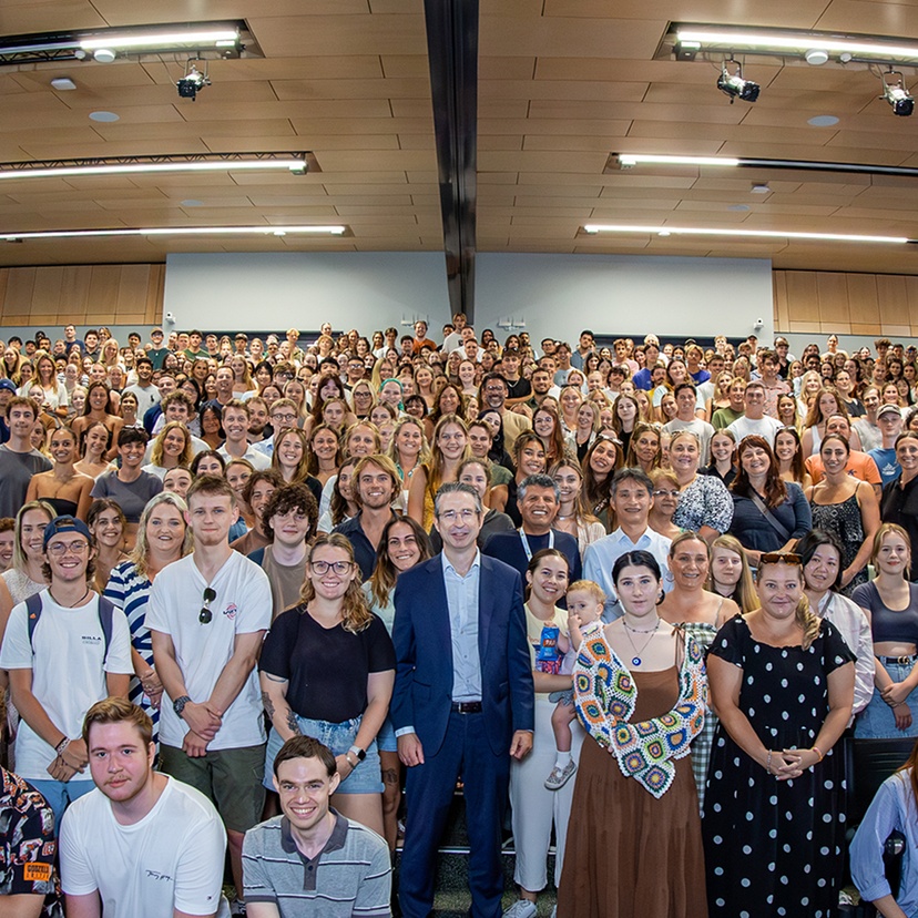 An enormous group of people in an auditorium looking at the camera
