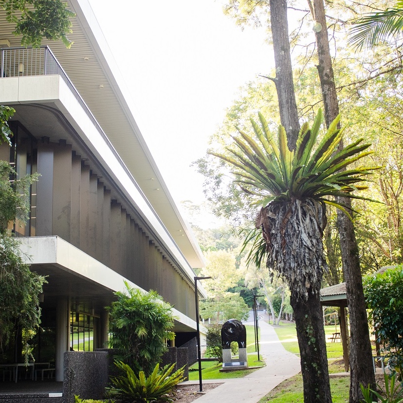 A modern building in a green forested campus