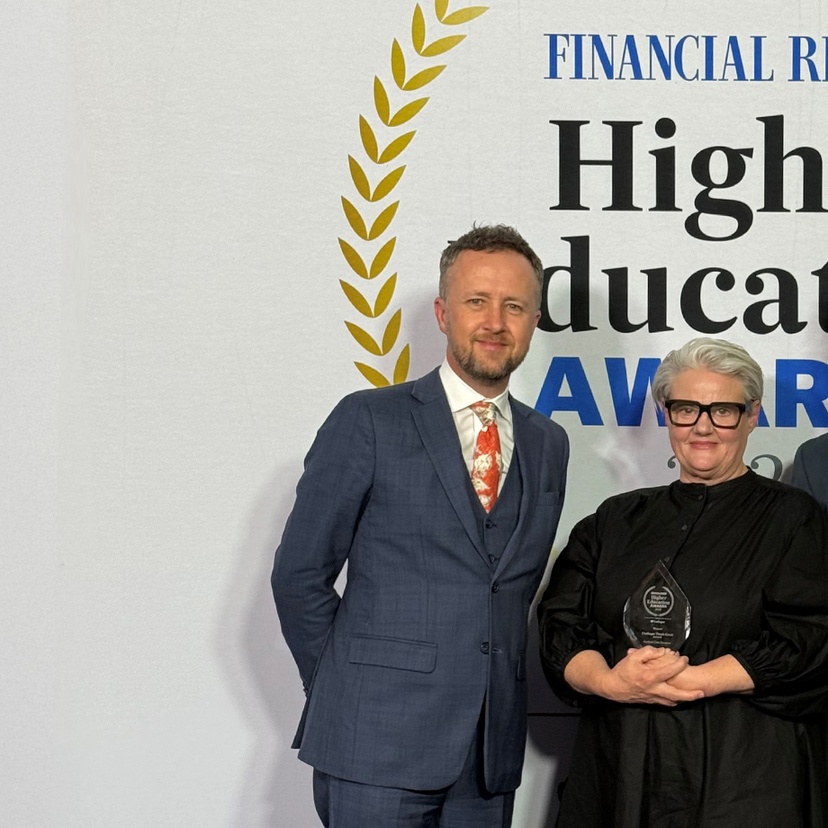 Three people standing in front of a banner
