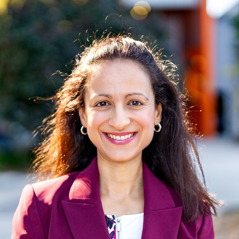A woman standing on a campus looking at the camera