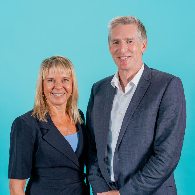 Woman and man in front of blue background