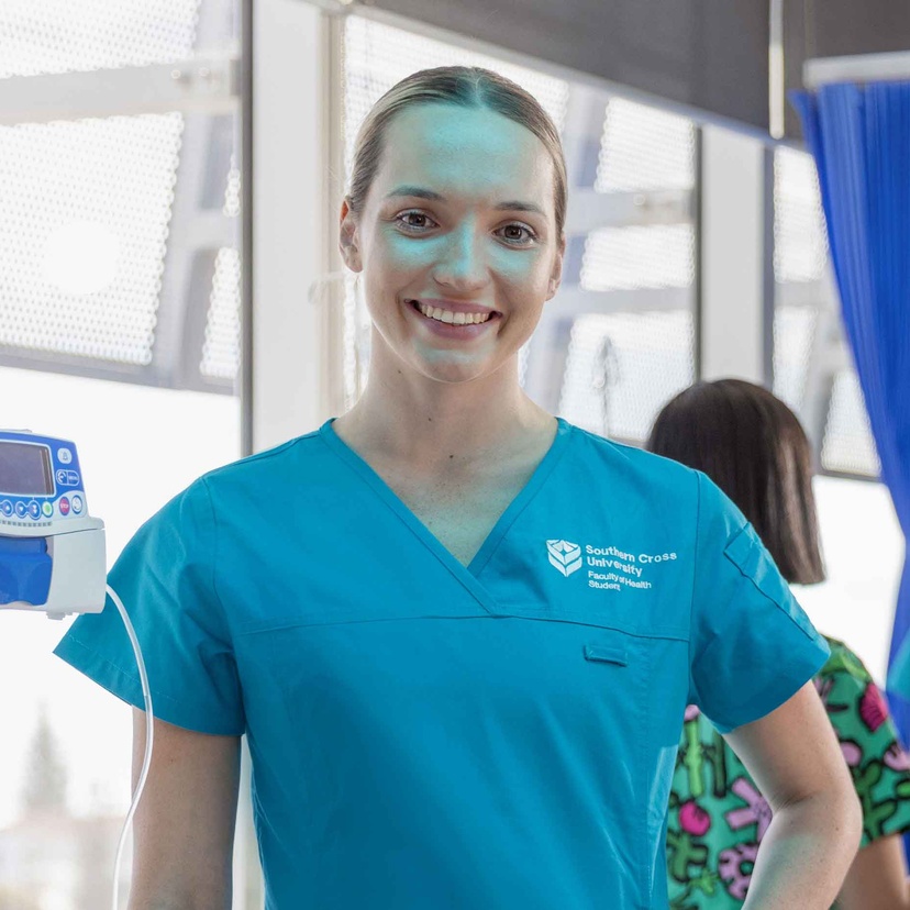 Female smiling at camera in scrubs