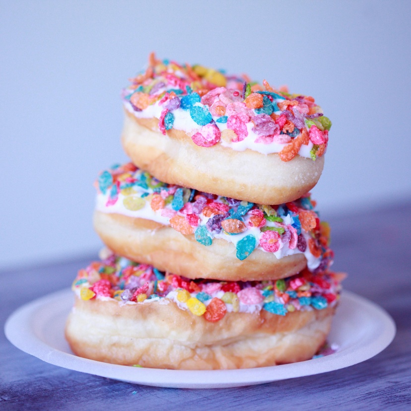 Three doughnuts stacked on a plate
