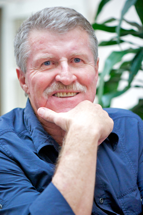 Man with grey hair and moustache smiling