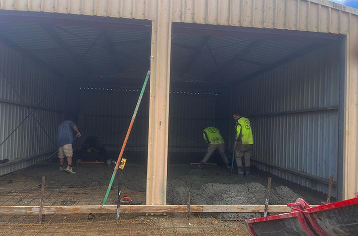 Events and News Workers level concrete floor inside shed