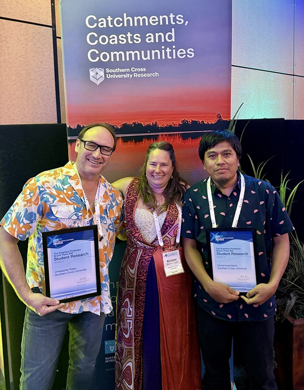 3 people in front of a coastal banner