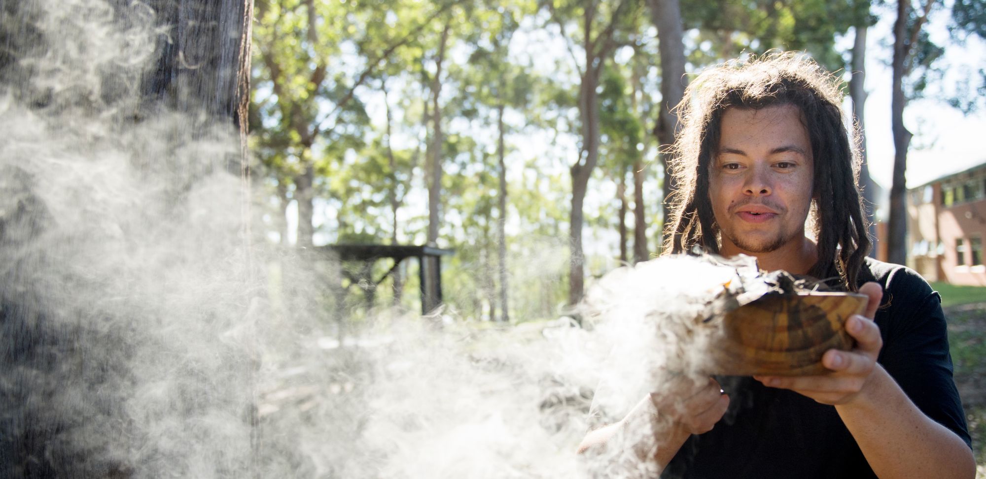 Man with smoking bowl in the bush