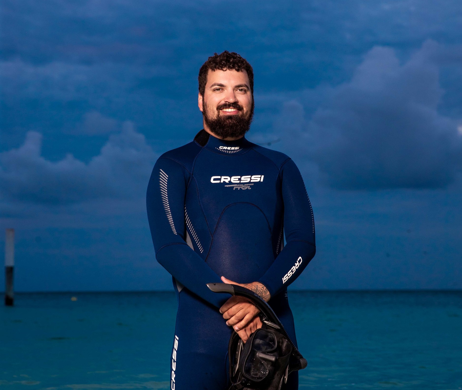 Jordan Ivey standing with in the sea with a wetsuit