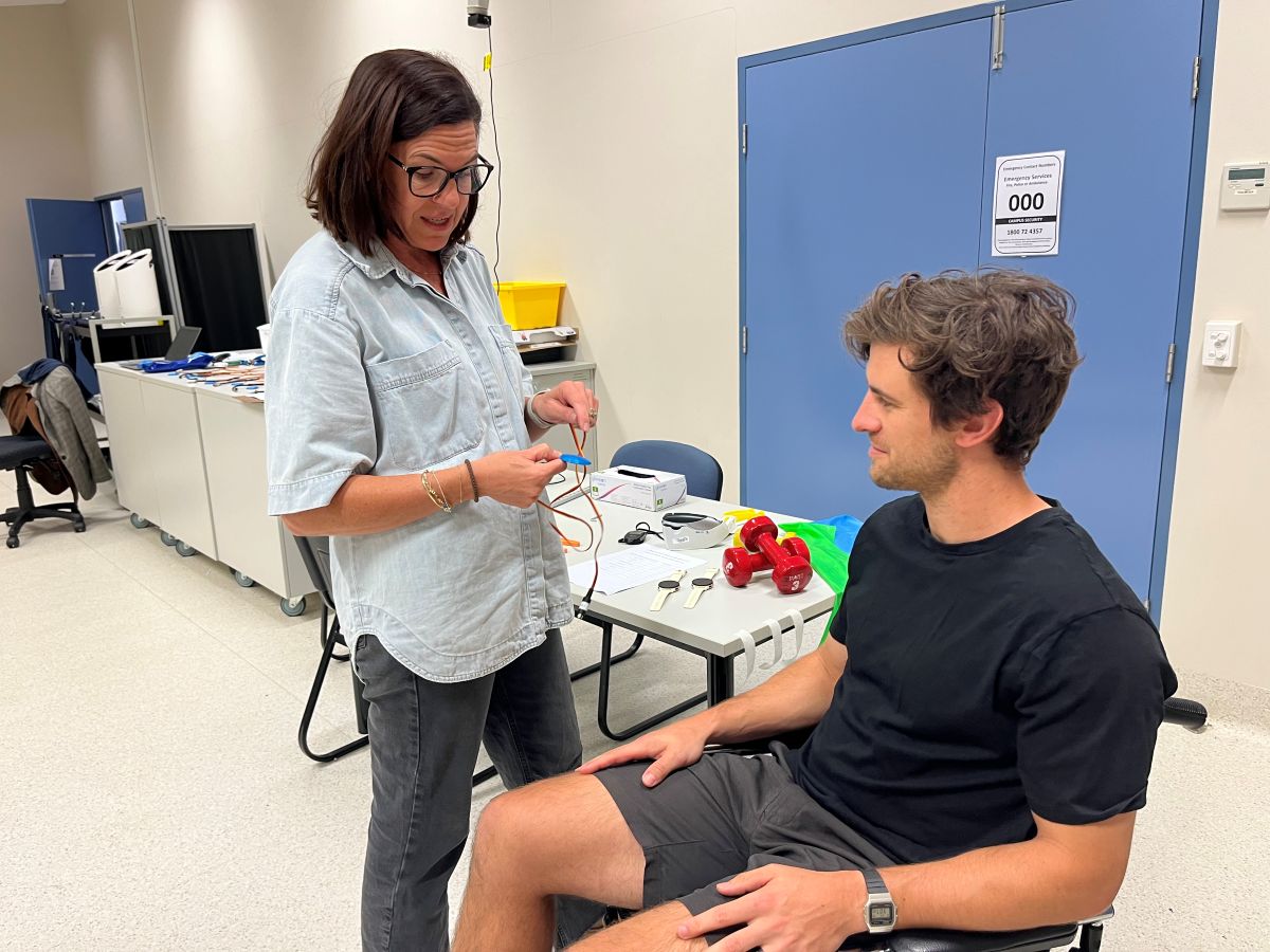 Liz Couzens Occupational therapist with patient Woman in glasses standing next to man in wheelchair