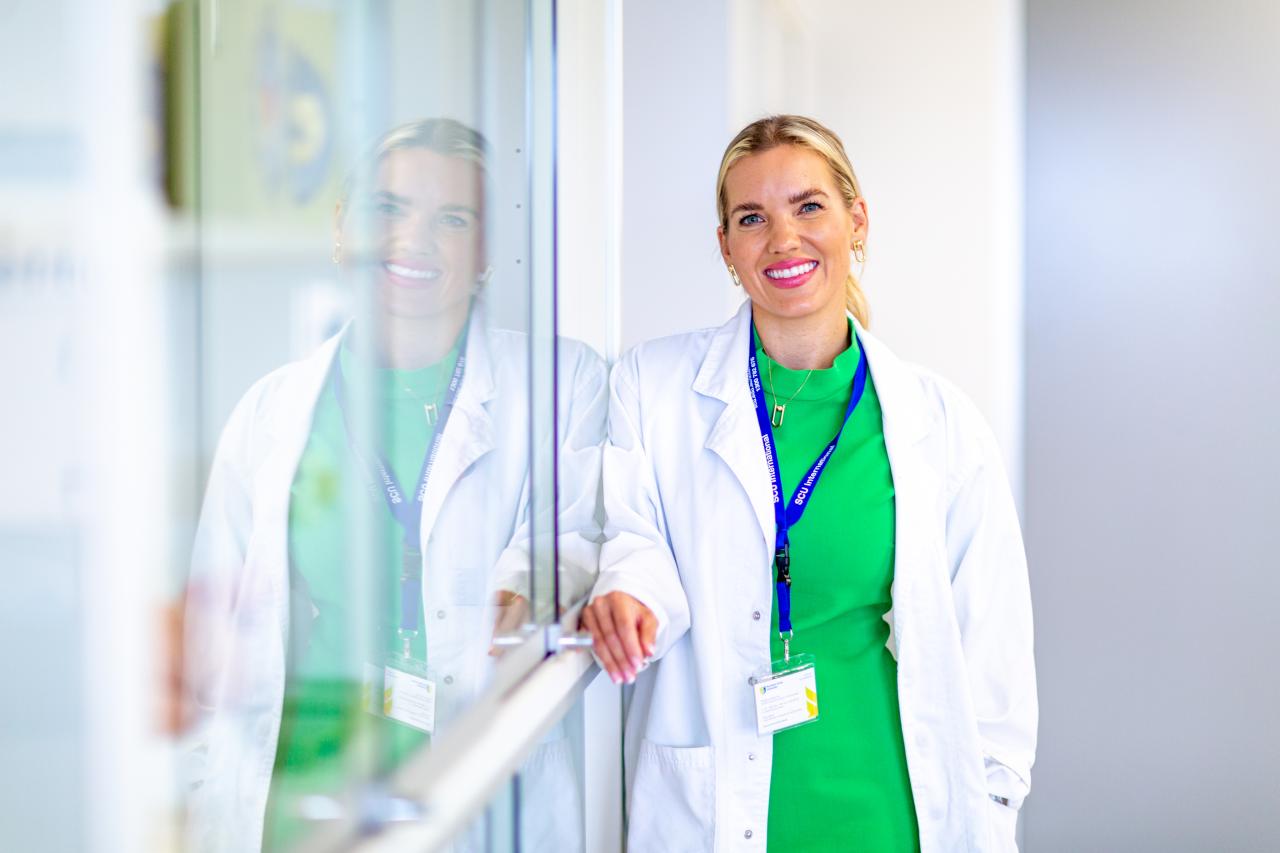 Woman in lab coat and green dress