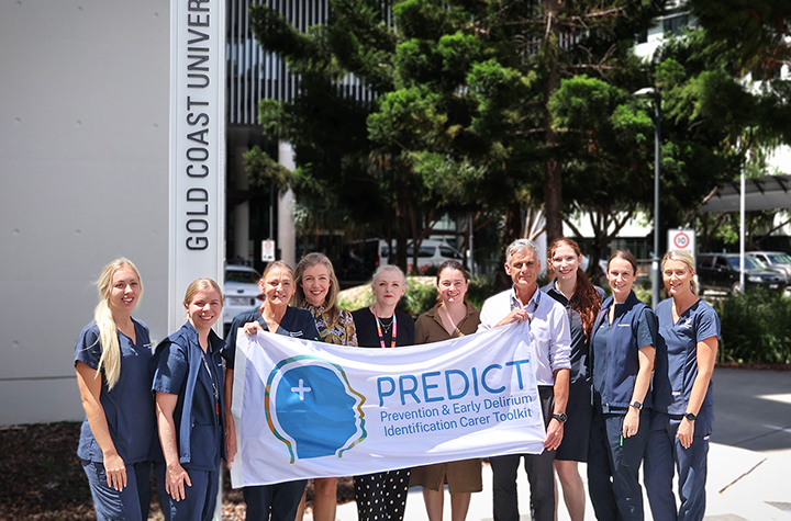 A group of people outside a hospital holding a banner