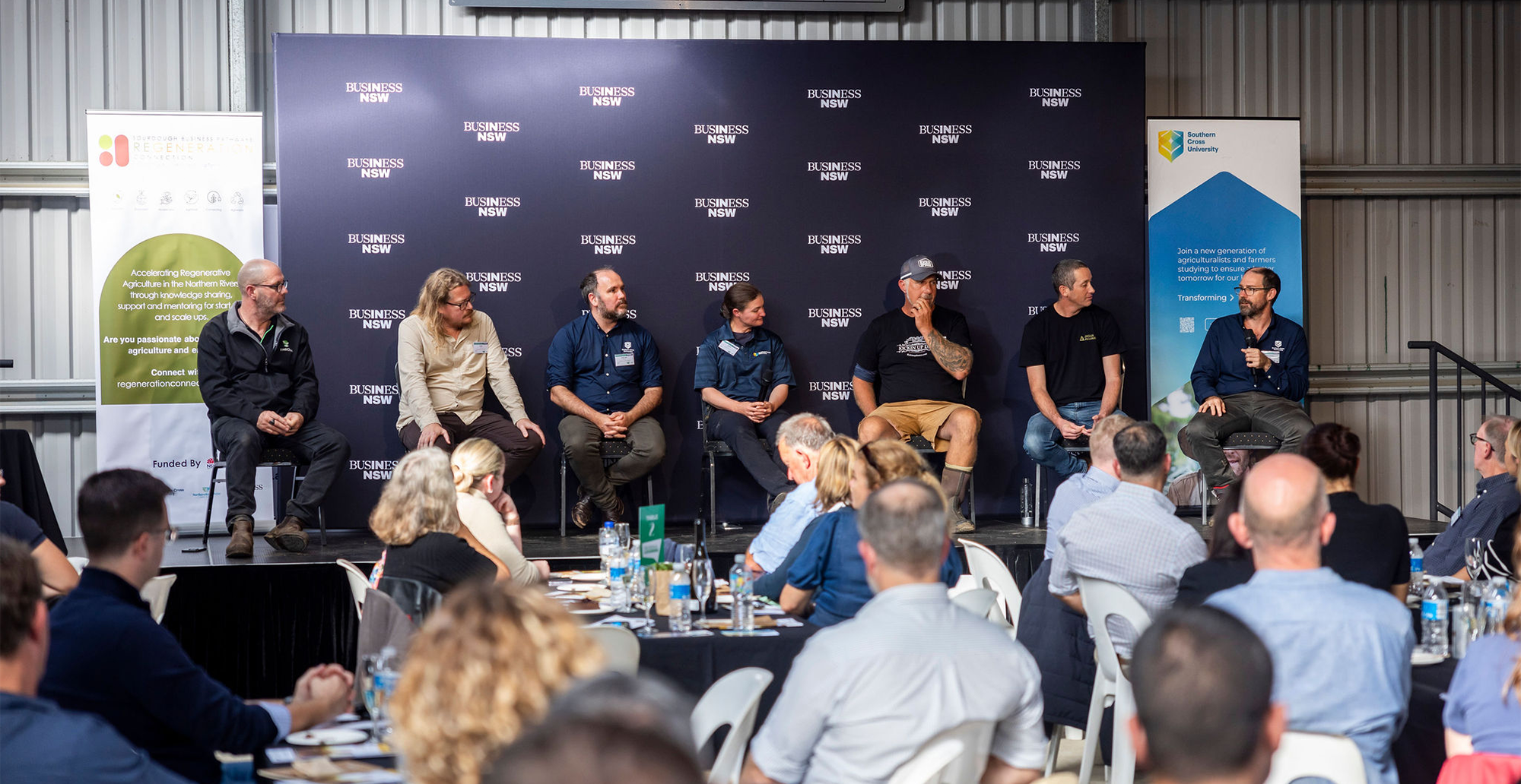 Panel of people on stage with crowd in foreground
